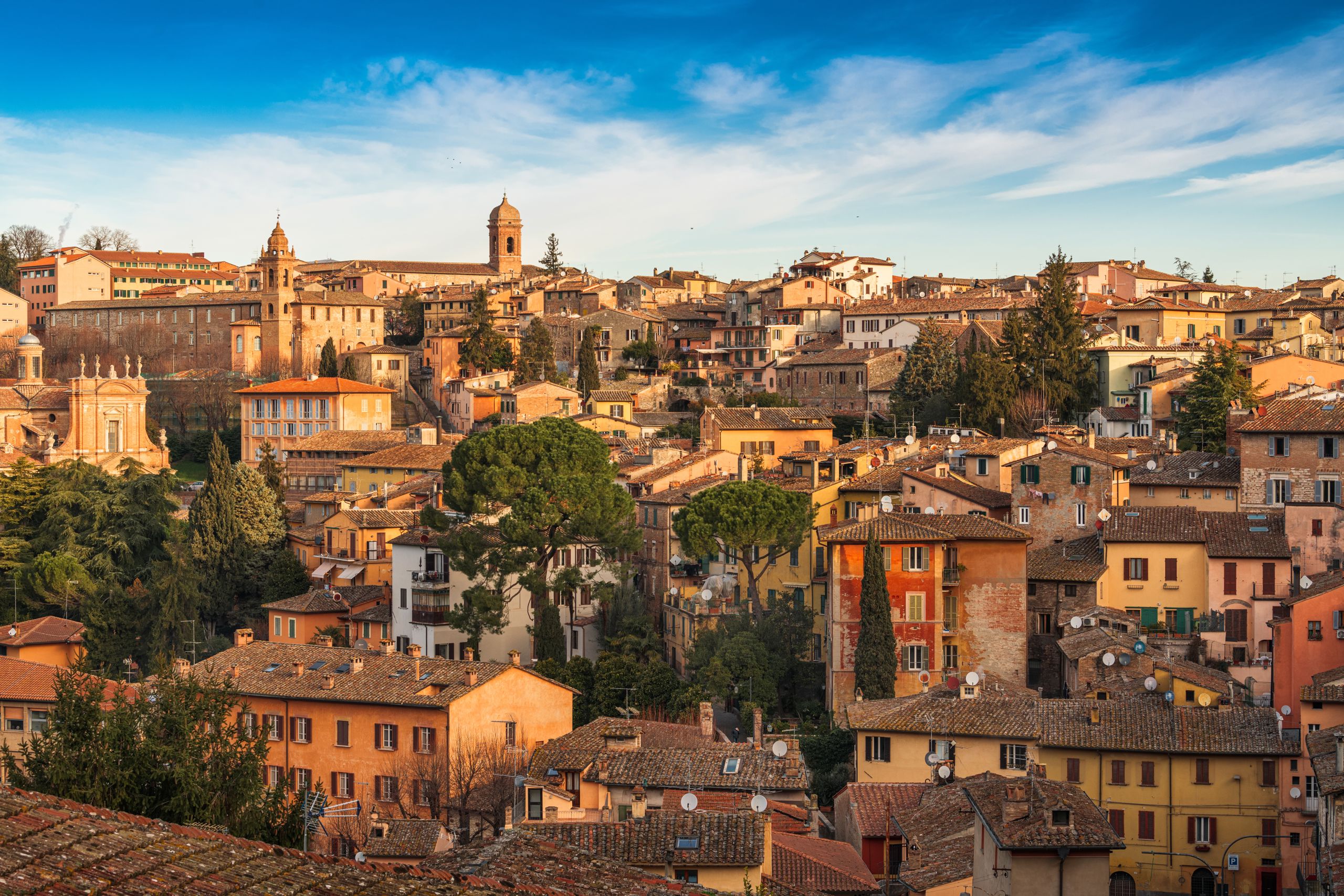 Bilde av gamlebyen i Perugia, Italia. Eldre murbygg i sjamerende stil, med blanding av hus og trær.