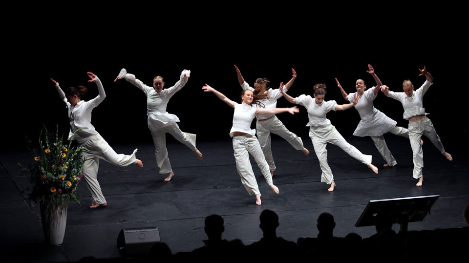Foto av kvinner kledd i kvitt frå dansekompaniet Terpsichore. Dei er på scena i Mimes brønn. 