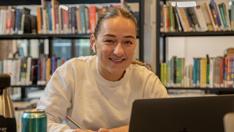 En kvinnelig student som smiler til kamera.