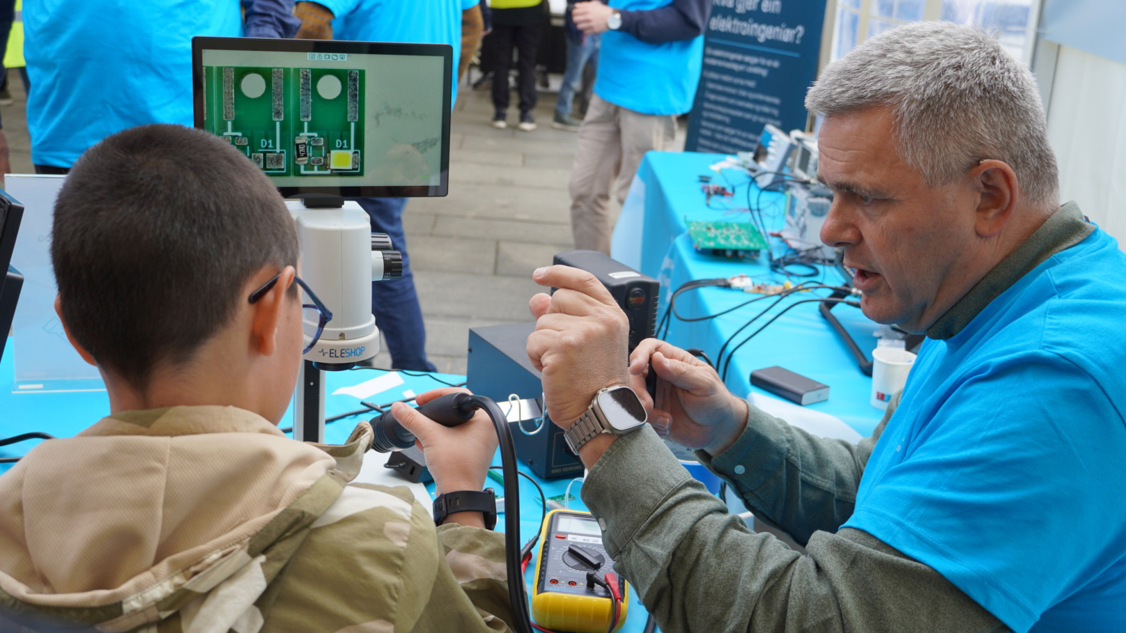 Mathias Mathiesen veileder og viser et barn hvordan man får elektronikken til å virke. 