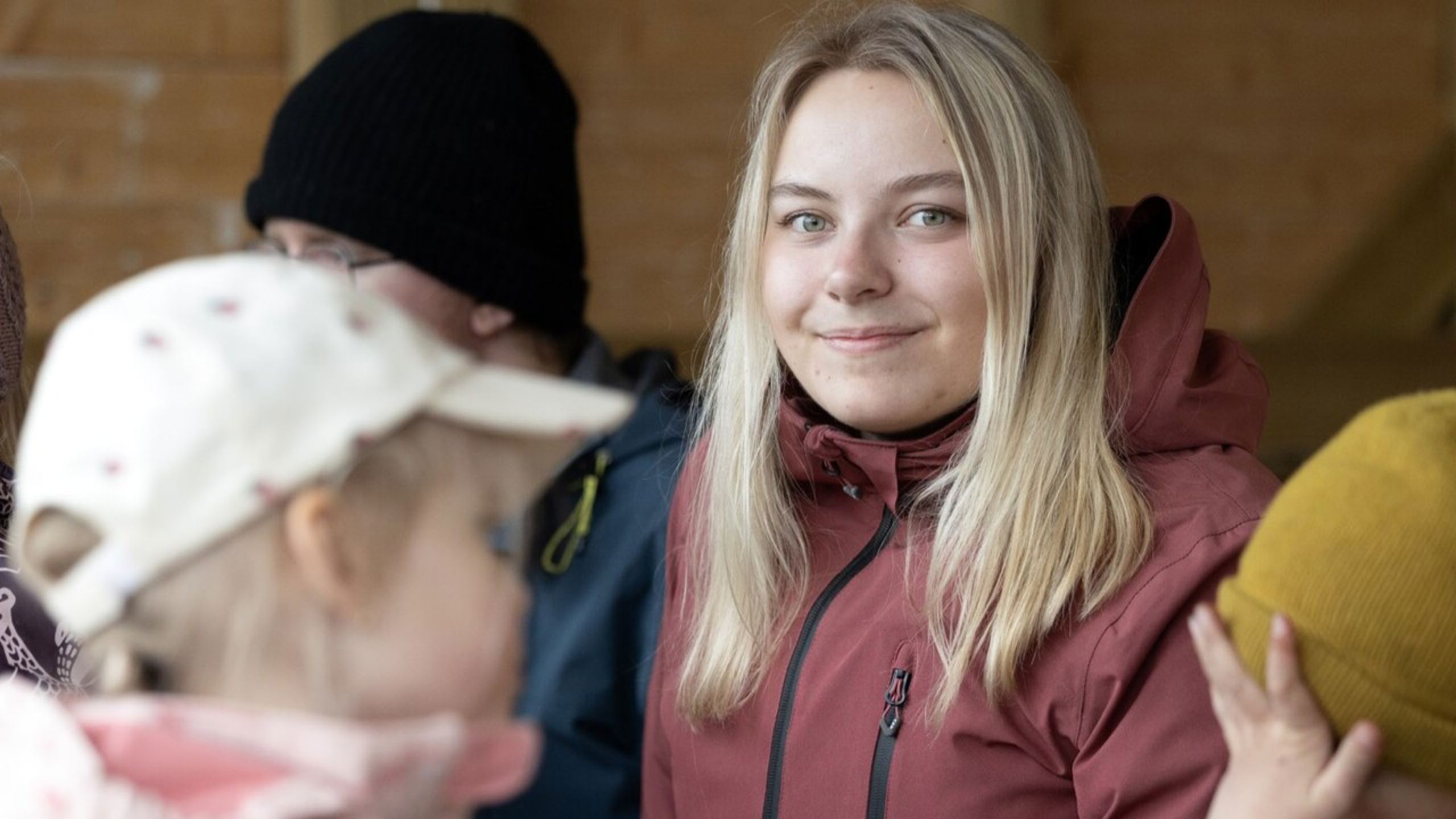 Barnehageansatt spiser lunsj med barna ute