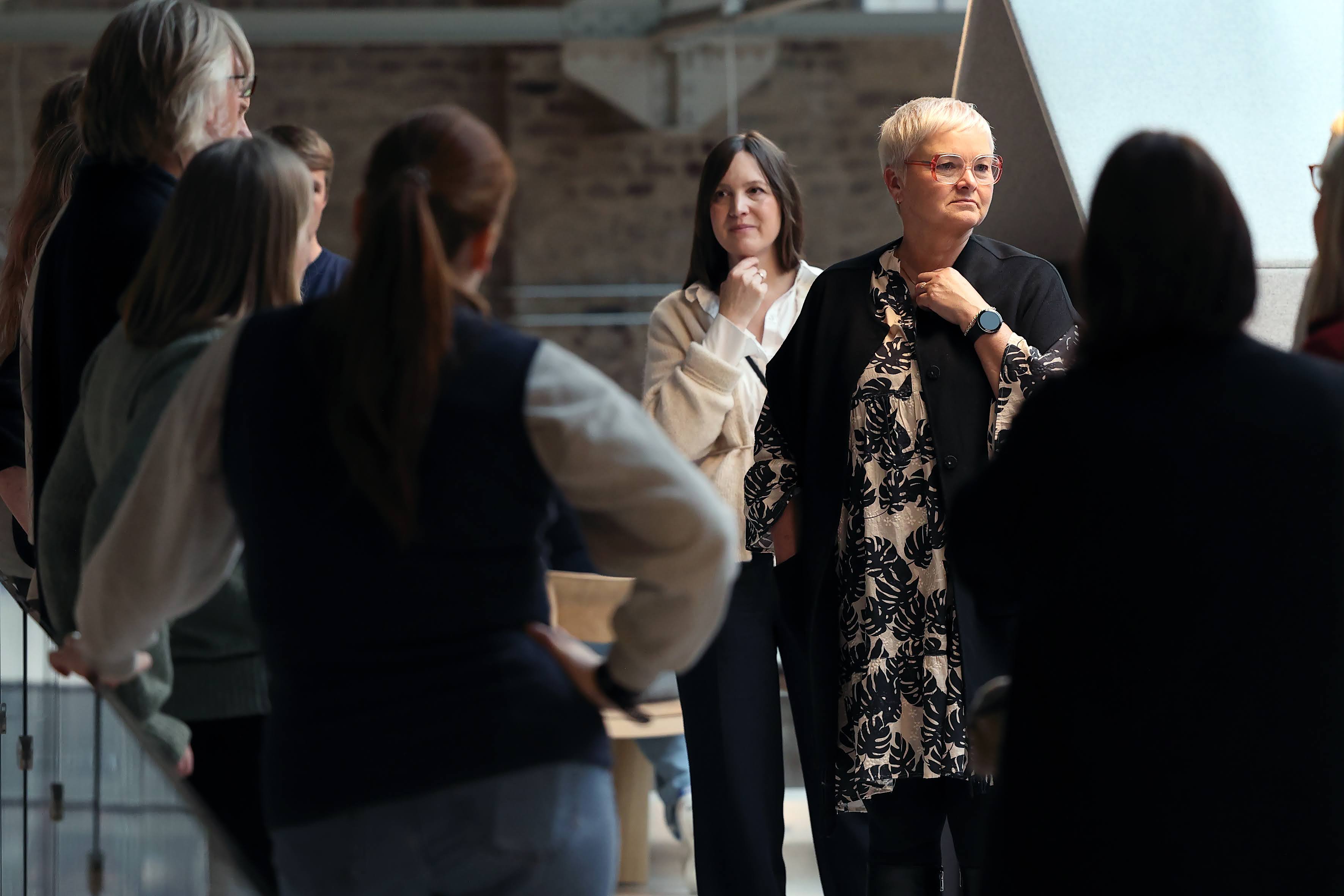 Ein folkemengde på synfaring på K1. Bak ser ein mursteinsveggar. Til høgre i midten av bildet står prorektor for utdanning, Anne-Grethe Naustdal.