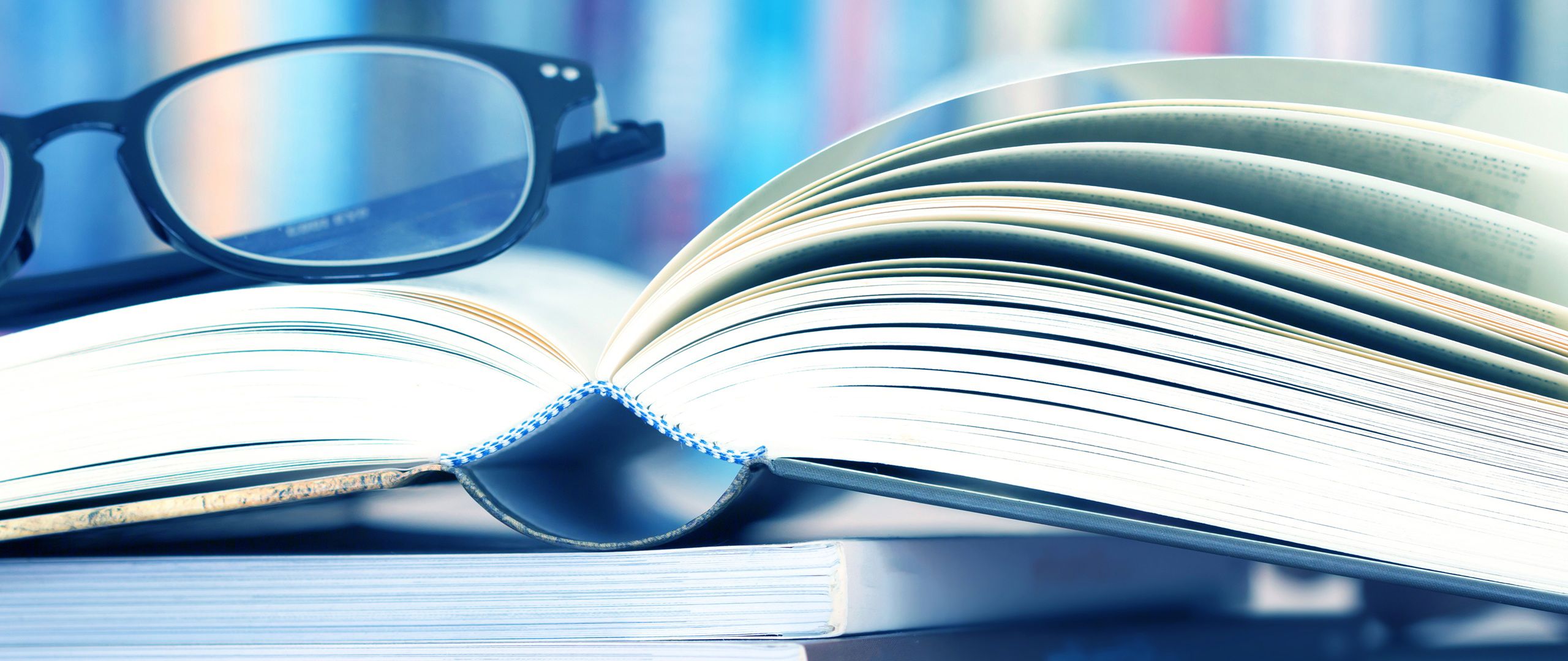 Briller hviler på en åpen bok