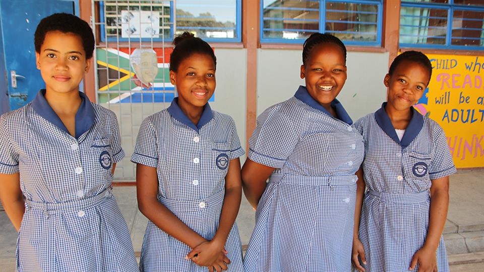 Fire skoleelever ved Lotusville School i Sør-Afrika, hvor lærerstudenter fra HVL om to år skal kunne ha praksisopphold. 