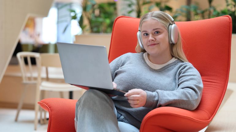 Jente i rød stol. Pc og headset