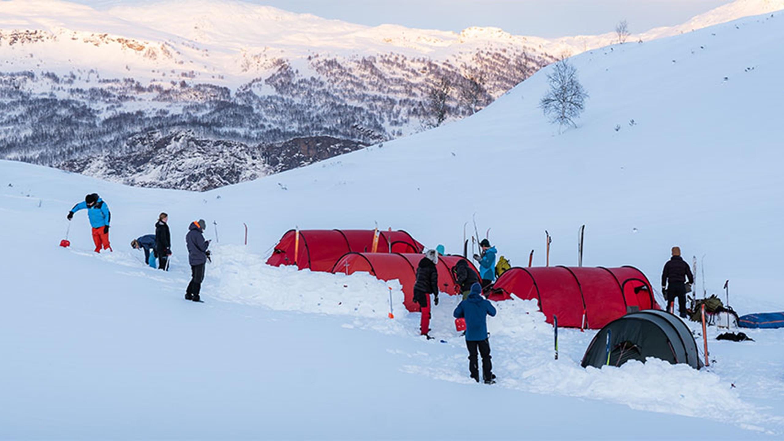 Students camping in the mountains on a snowy day