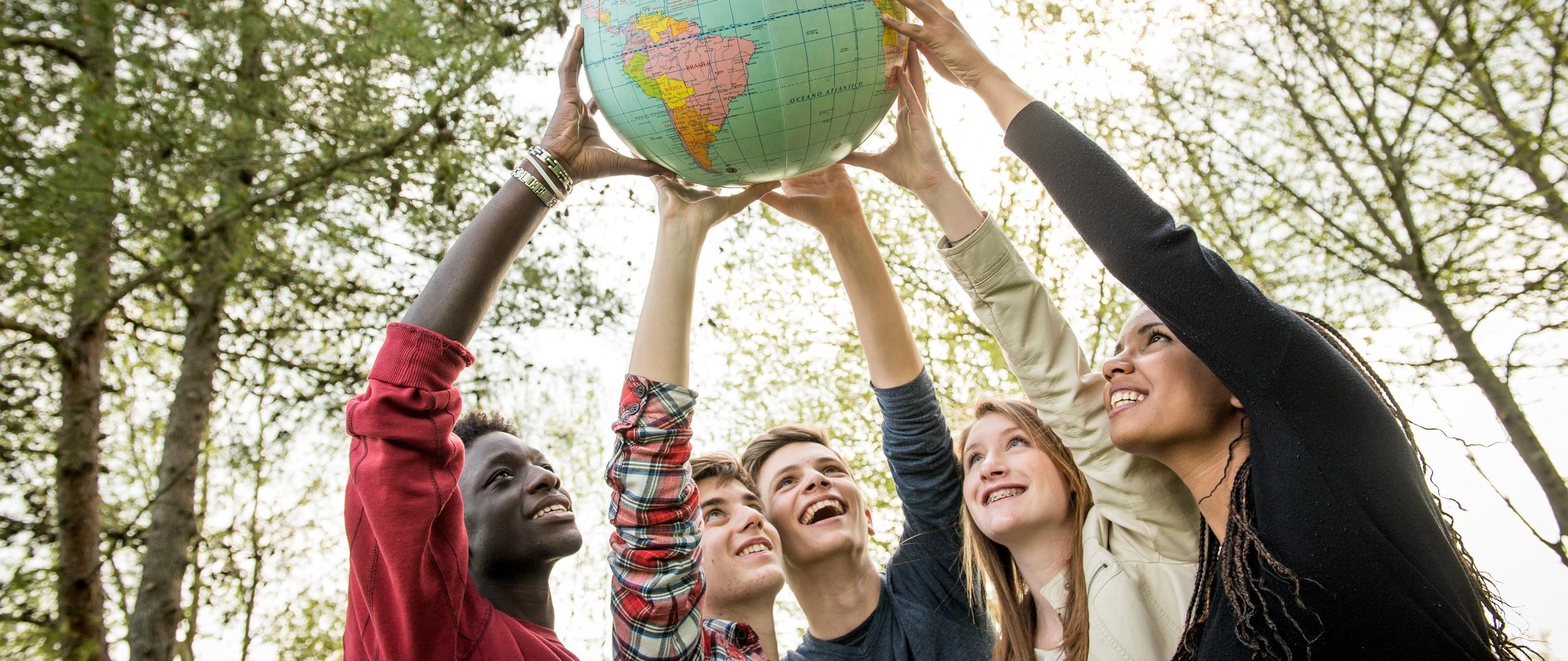 Young people holding a globe