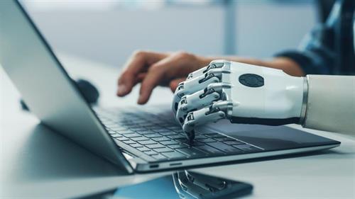 Bildet viser en menneskehånd og en hånd fra en robot på et datatastatur.