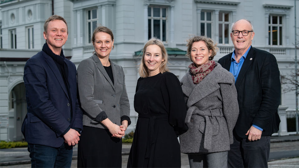 Medlemmer i styringsgruppa foran bygg.