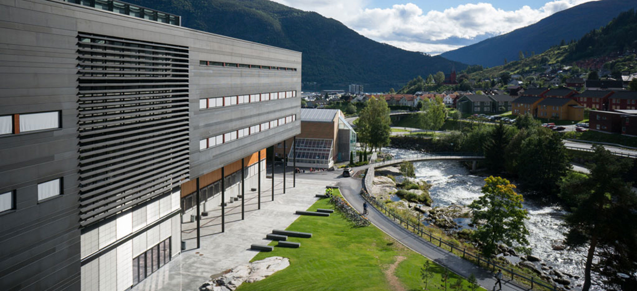 Building lovated by river and mountains. 