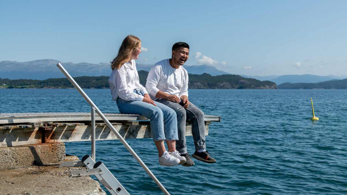 Studentar sitt på stupebrett ved sjøen