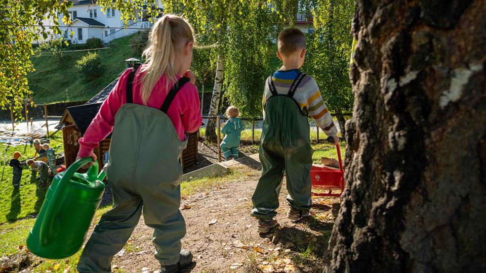Student i praksis i barnehage. I garderobe med eit barn.