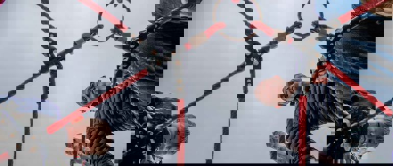 Barn og praksisstudent i klatrestativ.