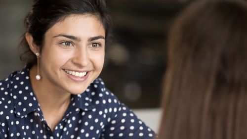 Smilande kvinne i samtale (illustrasjon)