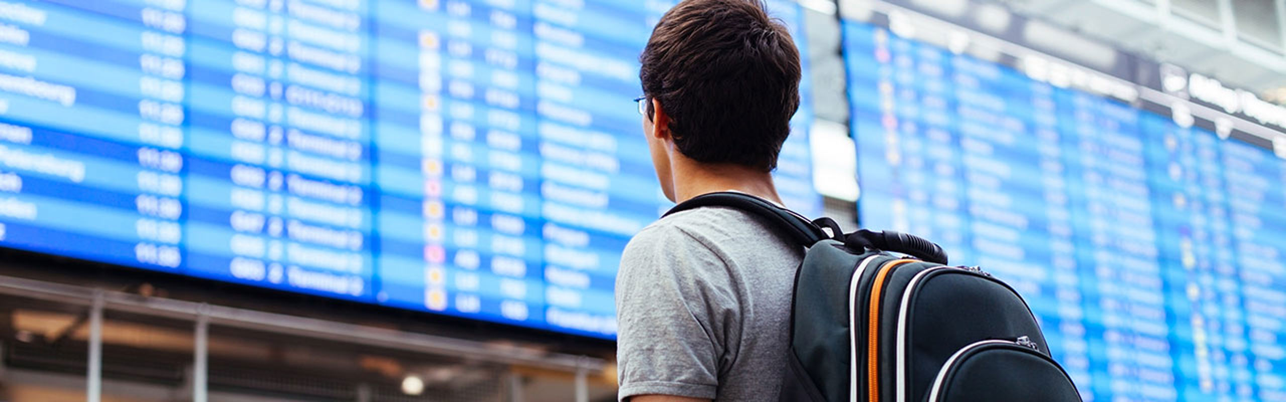Mann foran infotavle på flyplass.