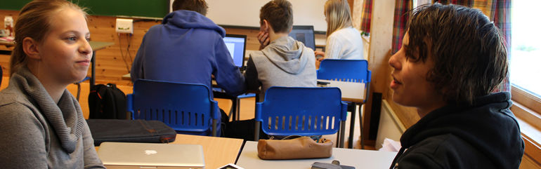 To ungdomsskuleelevar i samtale i klasserom