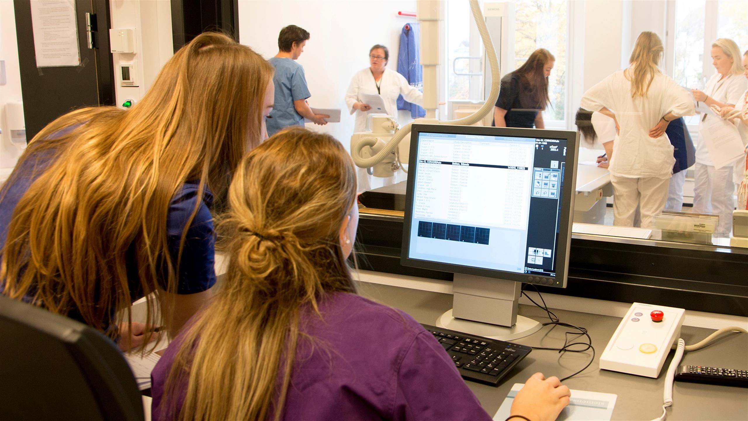 Radiografistudenter ser på datamaskin på kontrollrom